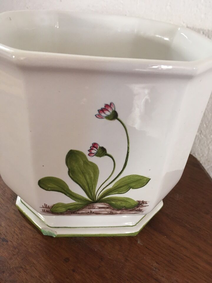 Cover - white ceramic pot decorated with stylized flowers.