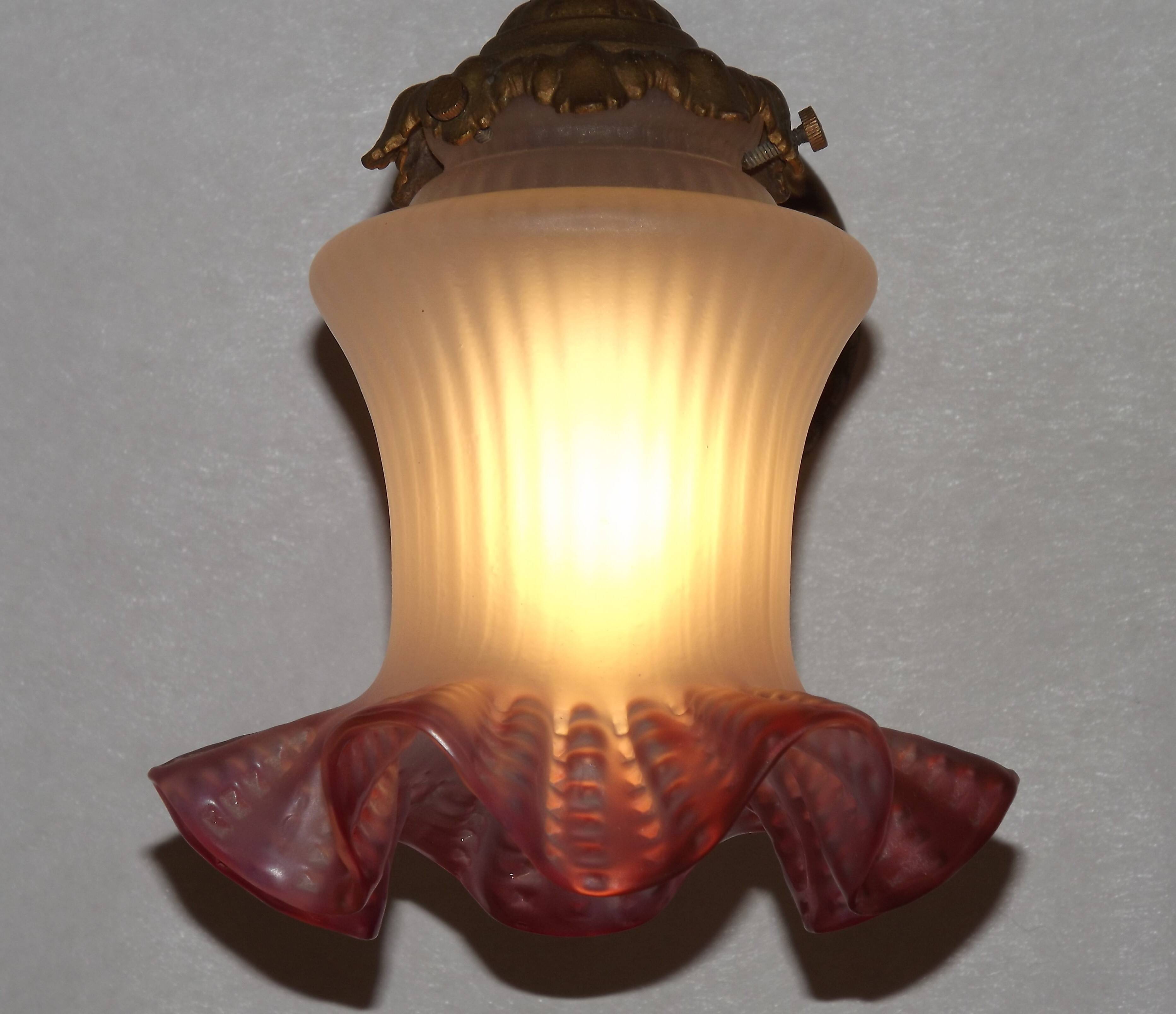 French Art Nouveau wall sconce in bronze with a white and pink glass shade.