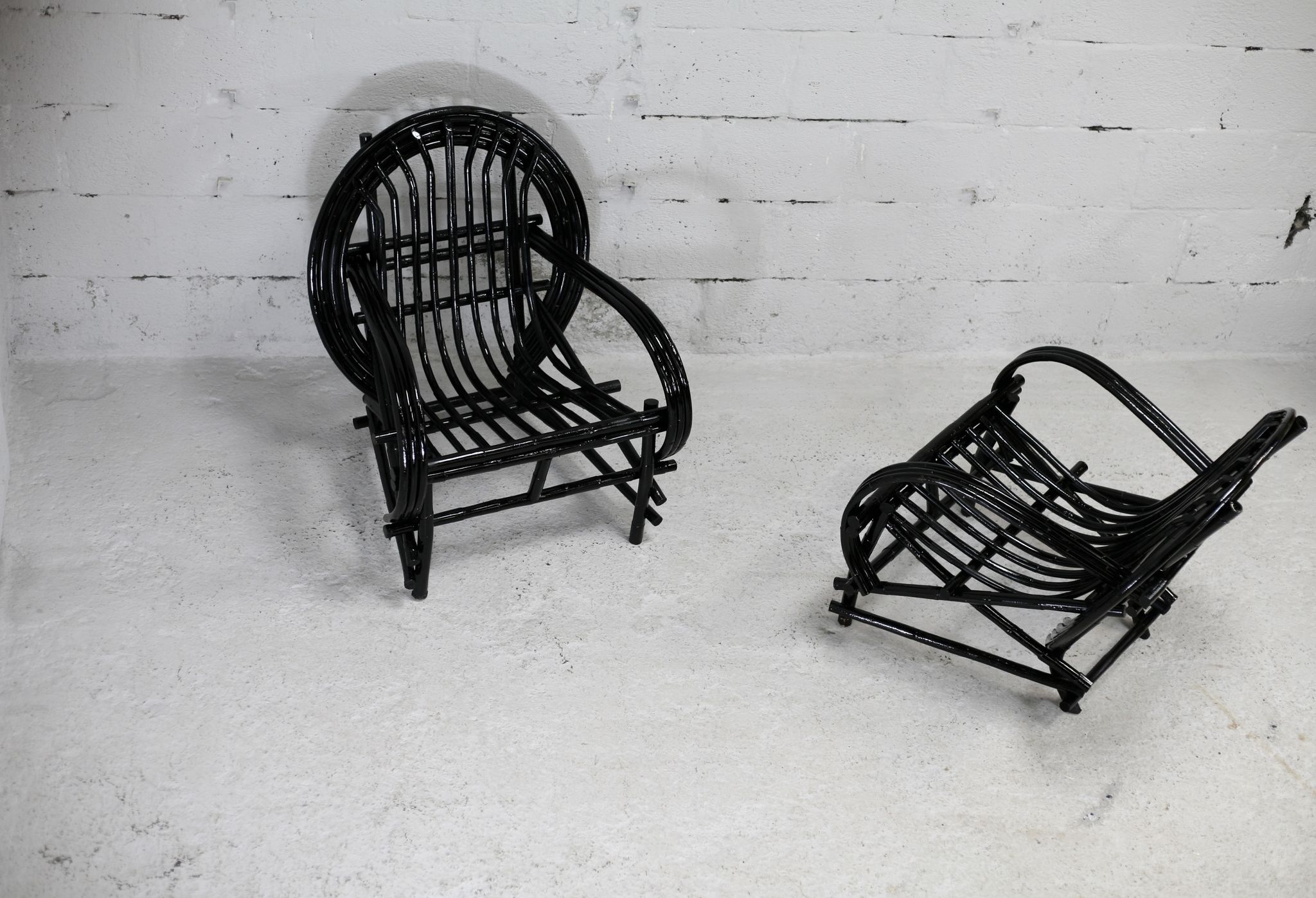 Pair of black lacquered rattan armchairs. France, cira 1960.
