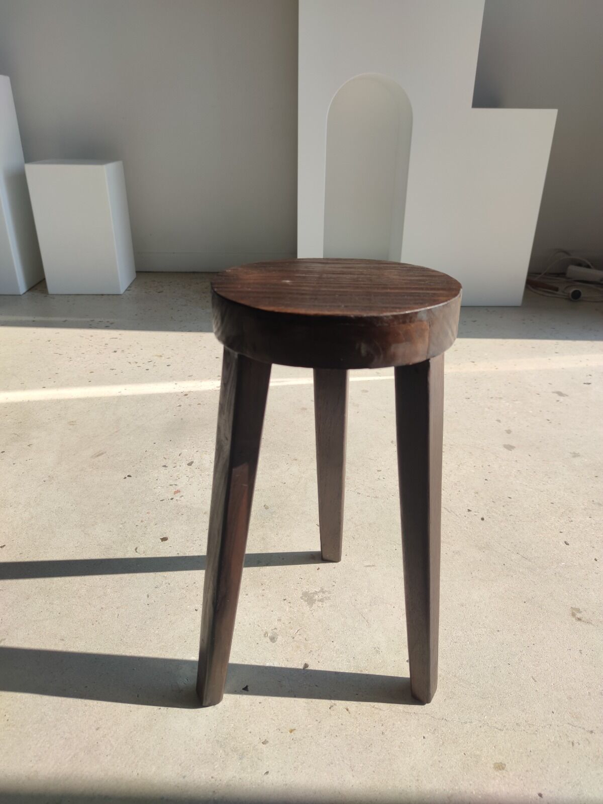 Small high tripod stool in brown solid wood