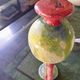 Small vintage glass vase with a red handle – Speckled green and yellow decoration