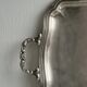 Silver metal serving tray with sculpted handles