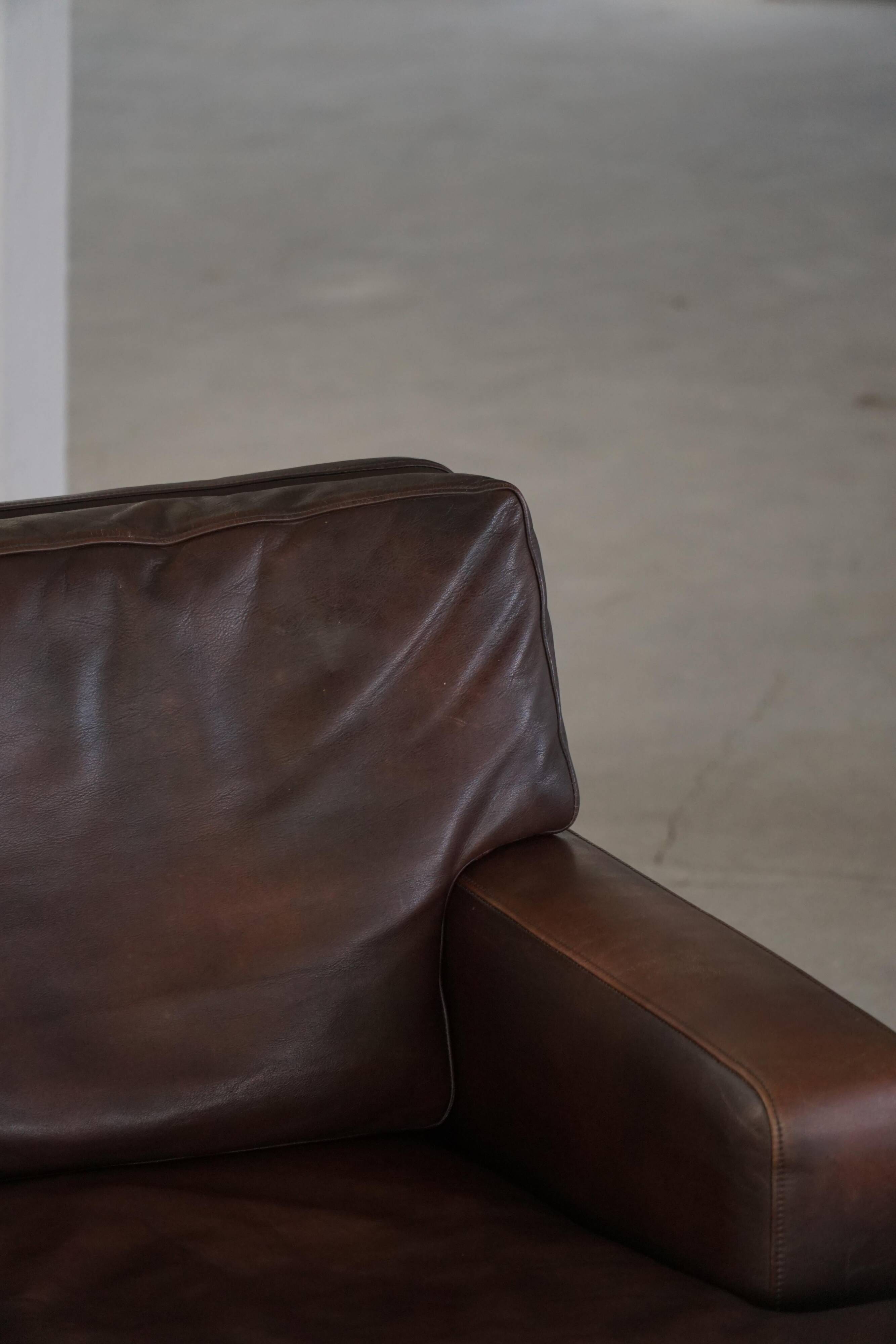 Pair of modern Danish lounge chairs in dark brown leather and rosewood, 1960s.