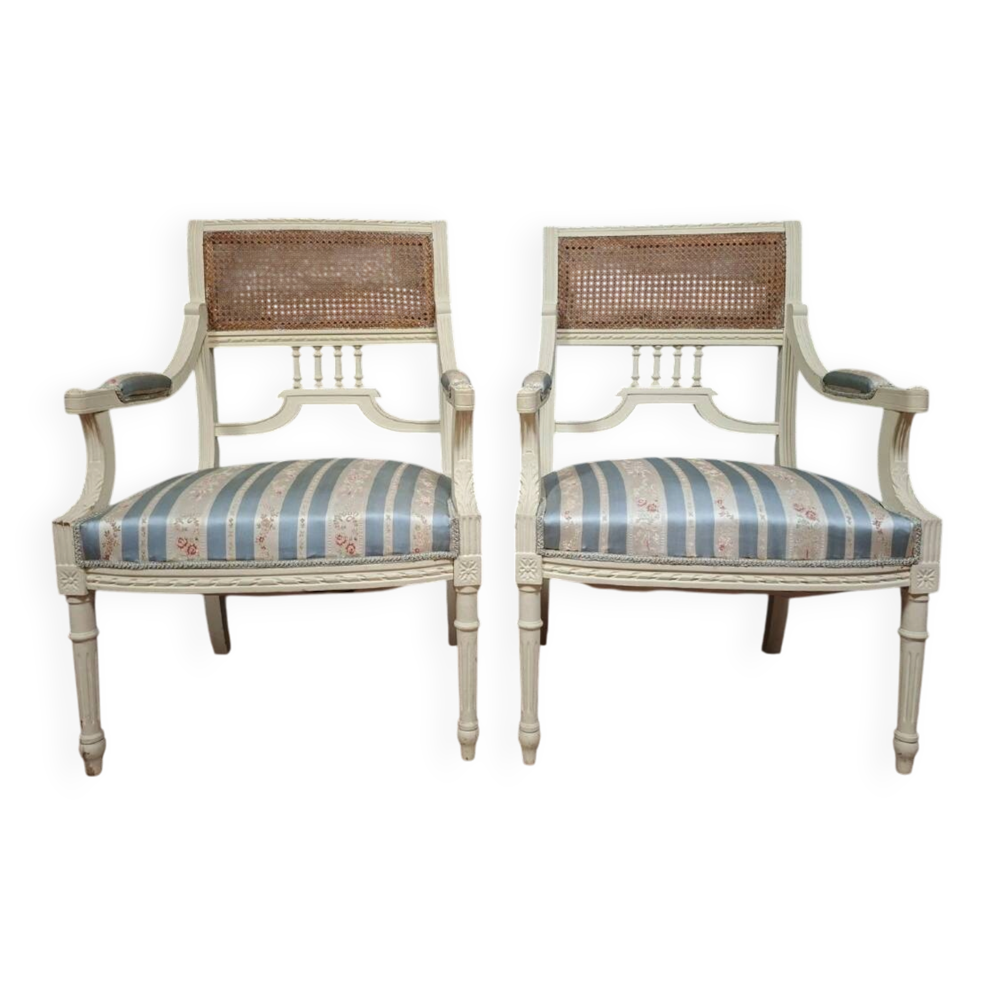 a pair of caned armchairs in the Louis XVI style, elegant and full of charm.