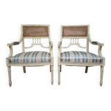 a pair of caned armchairs in the Louis XVI style, elegant and full of charm.