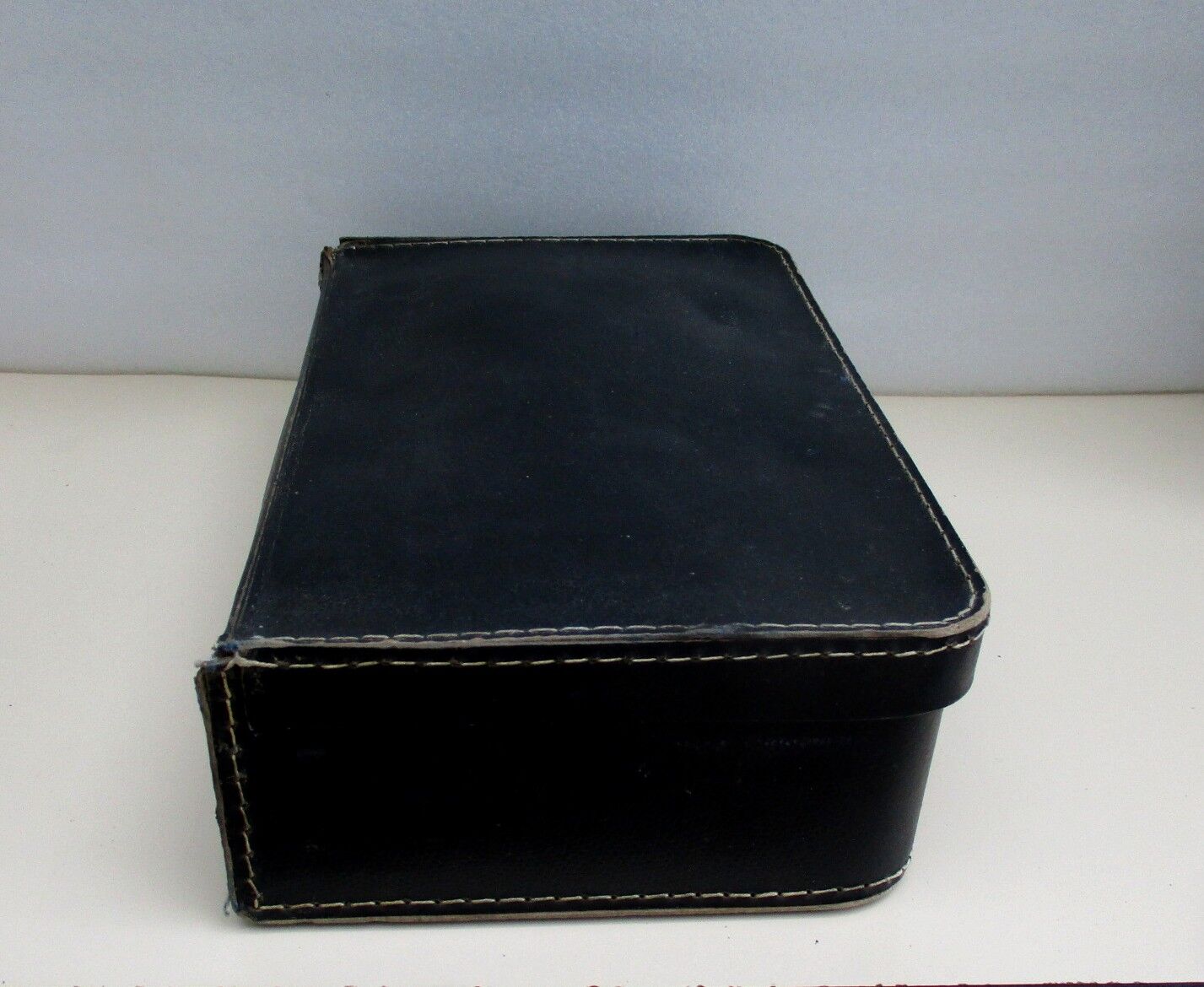 Small suitcase in old navy blue cardboard
