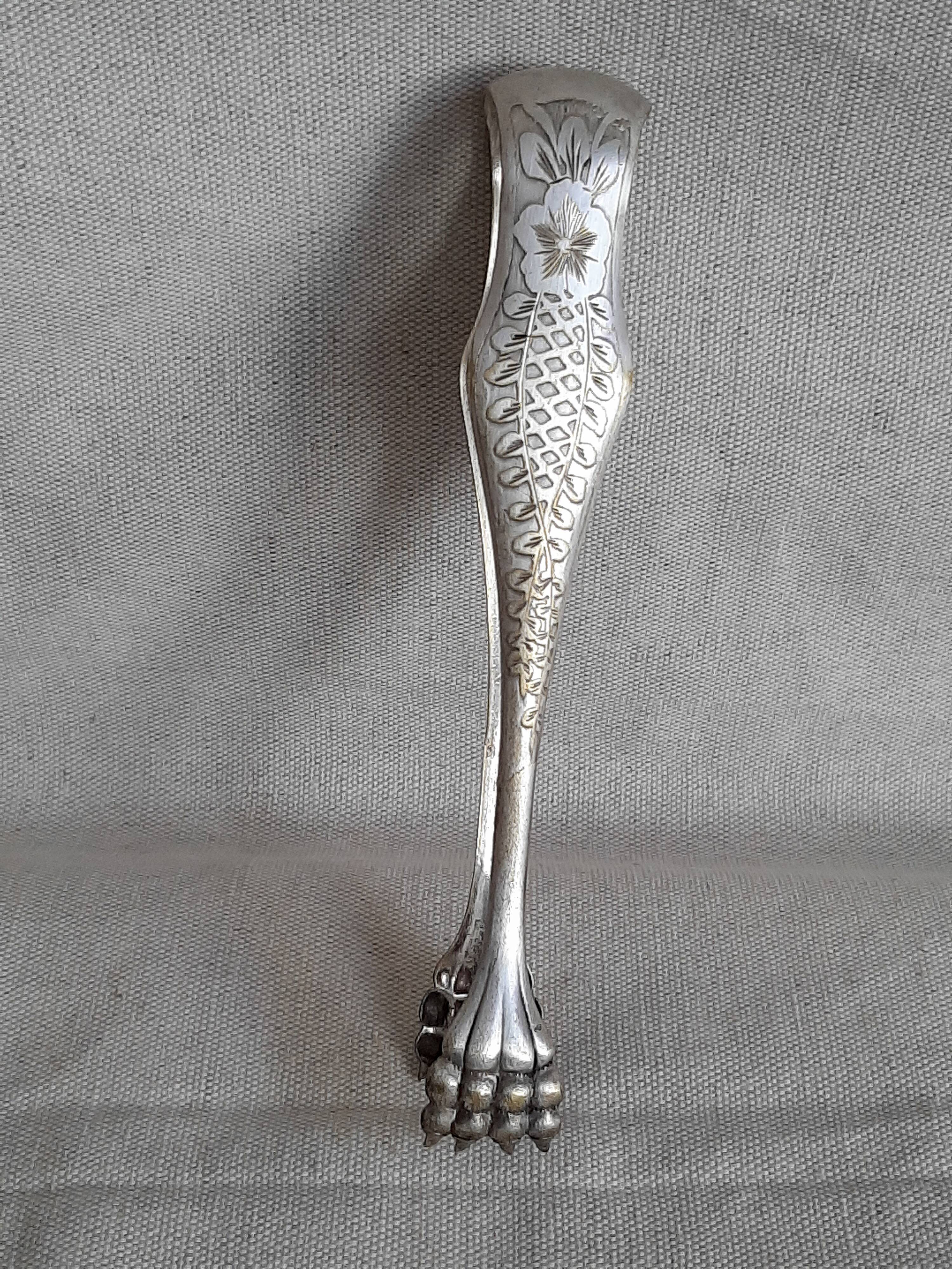 Antique silver-plated sugar tongs with lion's paws.