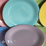Seven pastel-colored plates mixed with vintage earthenware
