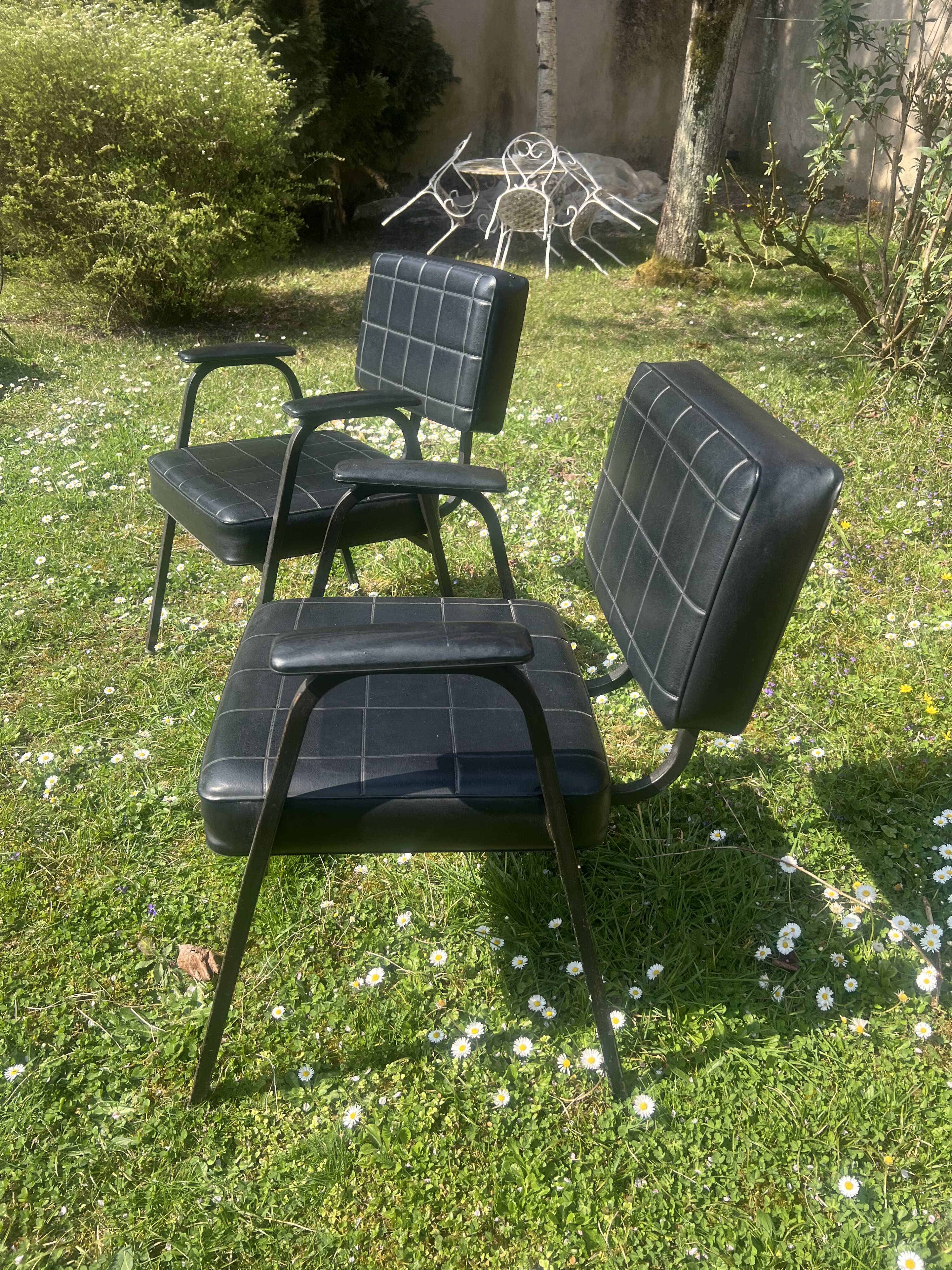 Pair of vintage industrial armchairs in black imitation leather and metal legs
