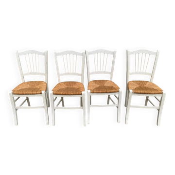 Set of 4 rustic white wooden chairs with straw seats.