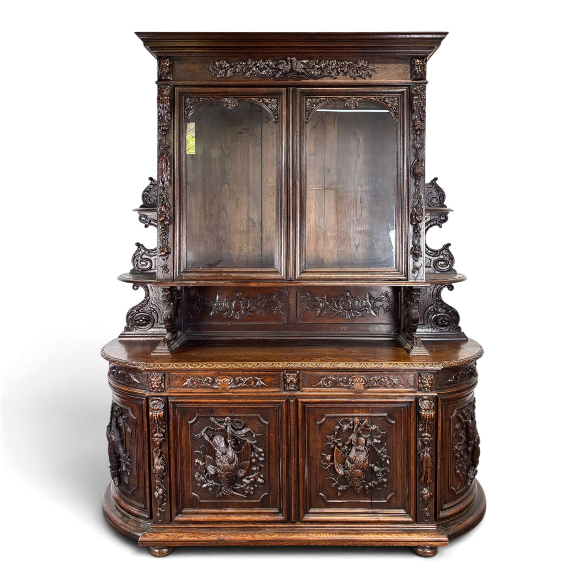 Buffet deux corps de chasse de style Henri II en chêne sculpté vitré