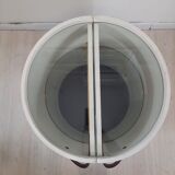 Armoire à barre vintage en forme de cylindre ouvrable, bois, laiton et verre.