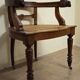 Fauteuil de bureau style Renaissance ancien en bois sculpté et assise cannée