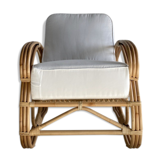 Fauteuil de repos en rotin et coussins blancs