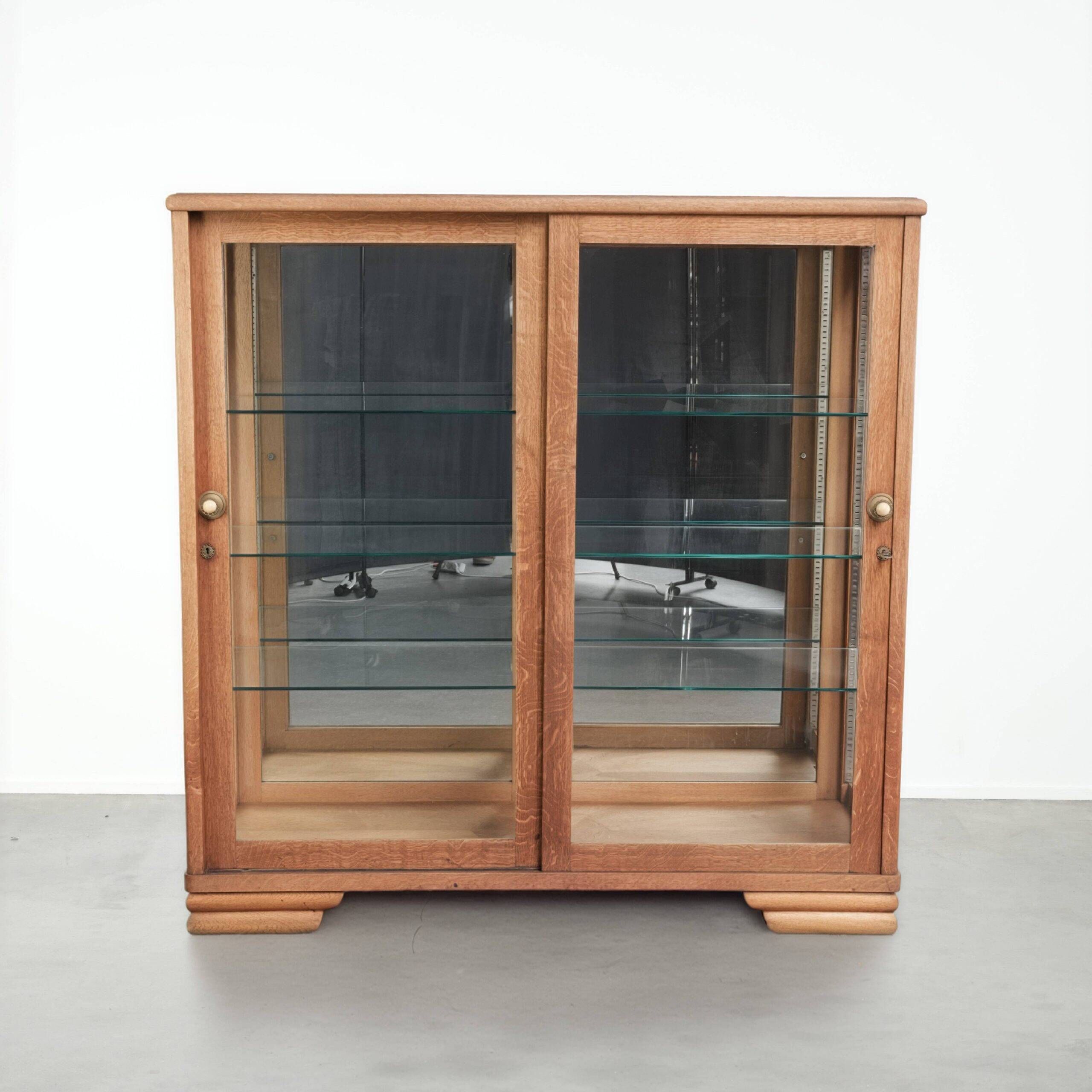 Antique Dutch oak display cabinet with glass shelves and a mirrored back