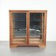 Antique Dutch oak display cabinet with glass shelves and a mirrored back