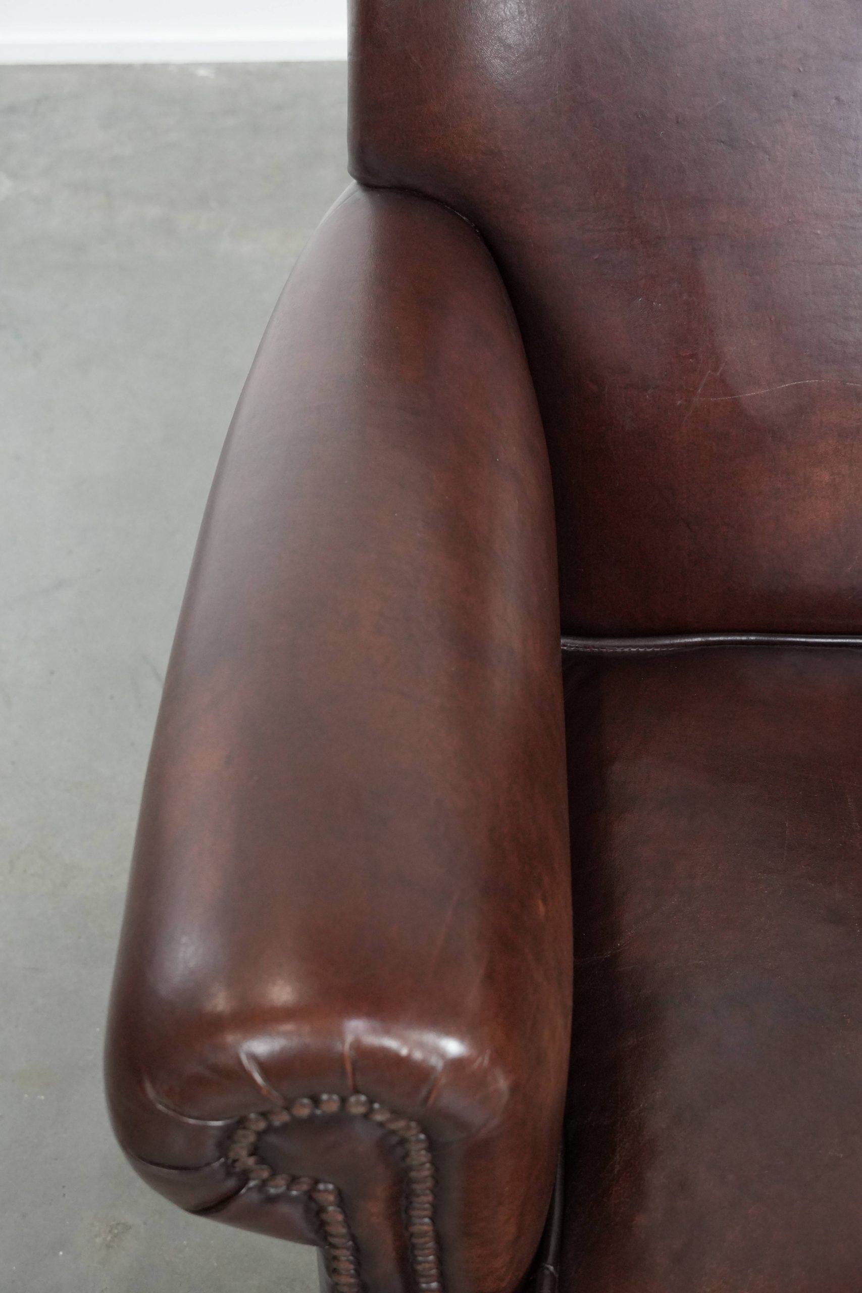 Sheepskin armchair with a classic finish and decorative studs.