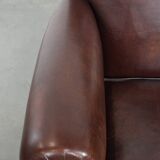 Sheepskin armchair with a classic finish and decorative studs.