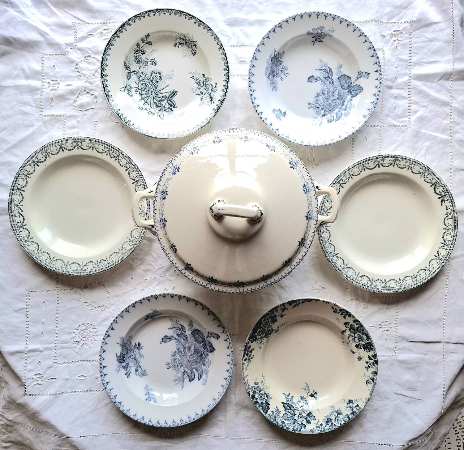 Antique mismatched earthenware soup plates with a tureen