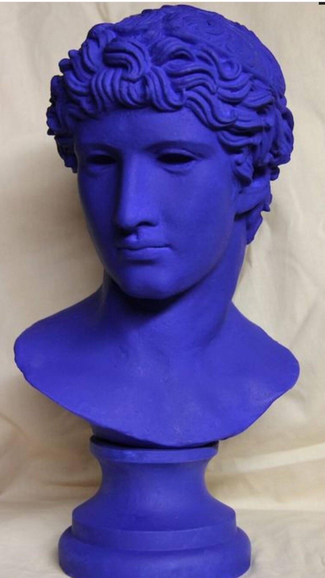 Large bust of a Greek Roman Apollo on a pedestal