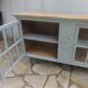 Vitrine vintage de faible profondeur sublimée en vert de gris plateau bois.