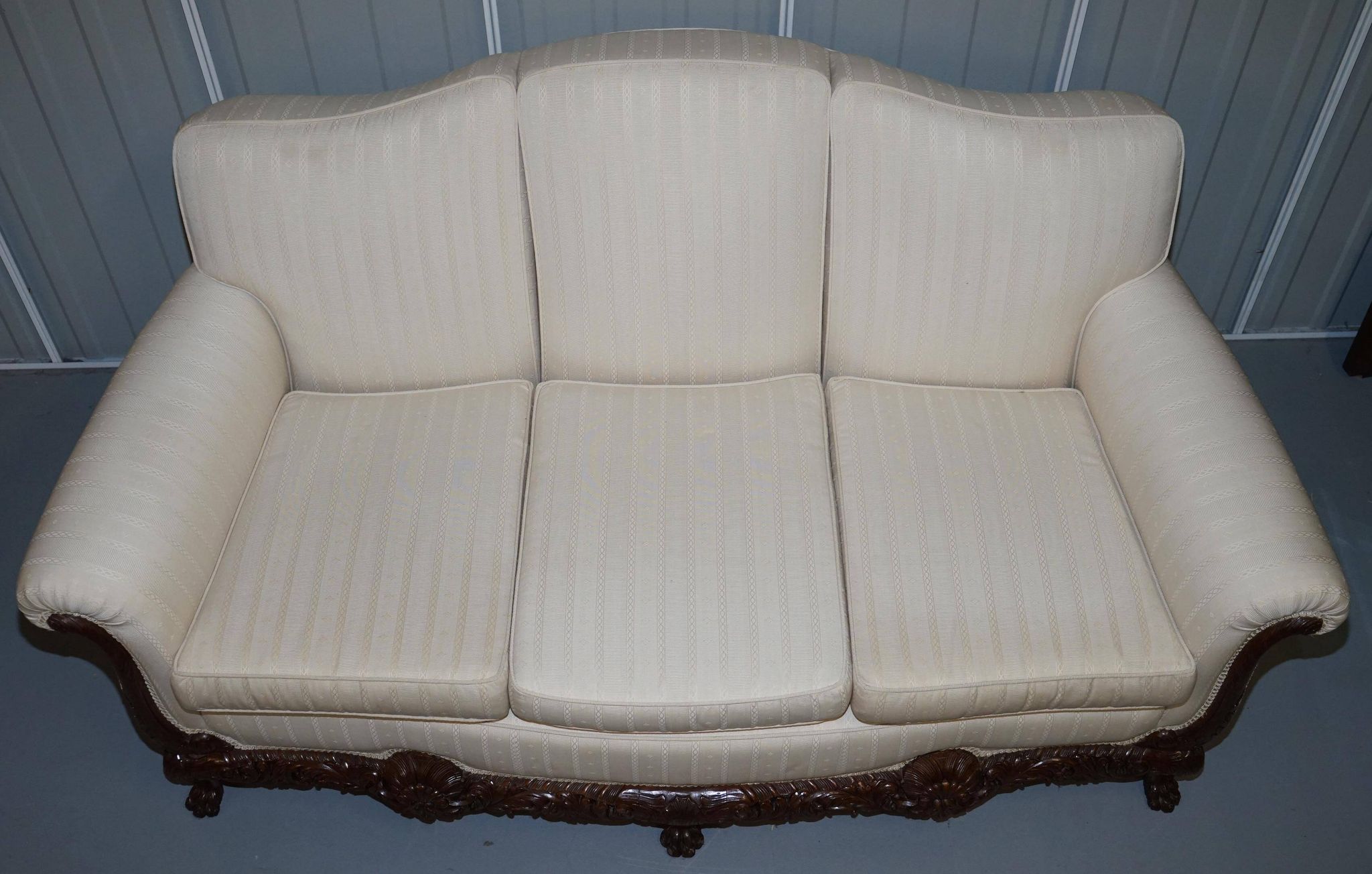 Three-seater canapé carved from solid walnut with claw feet.