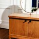 Vintage oak cabinet with circular mirror, 1960s modernist design.