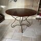 Table and four wrought iron and wood chairs.