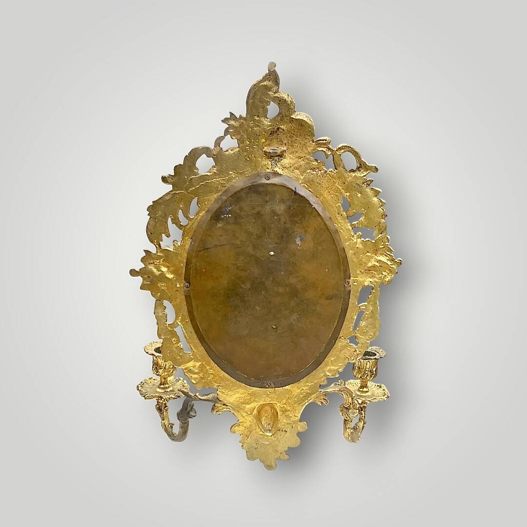 Antique bronze wall sconce with two candlesticks and beveled mirror
