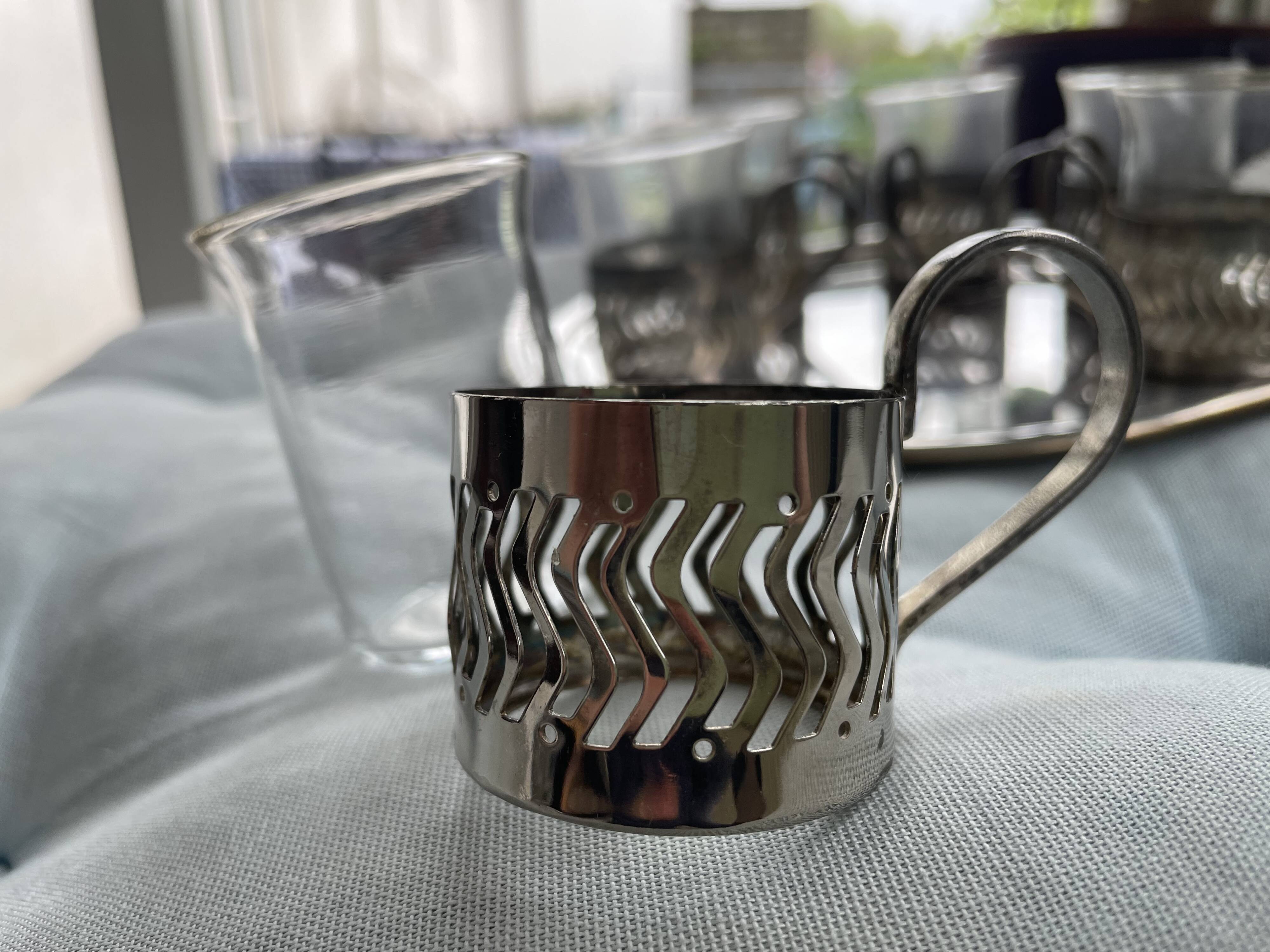 6 small glasses in their silver metal holder, with handle