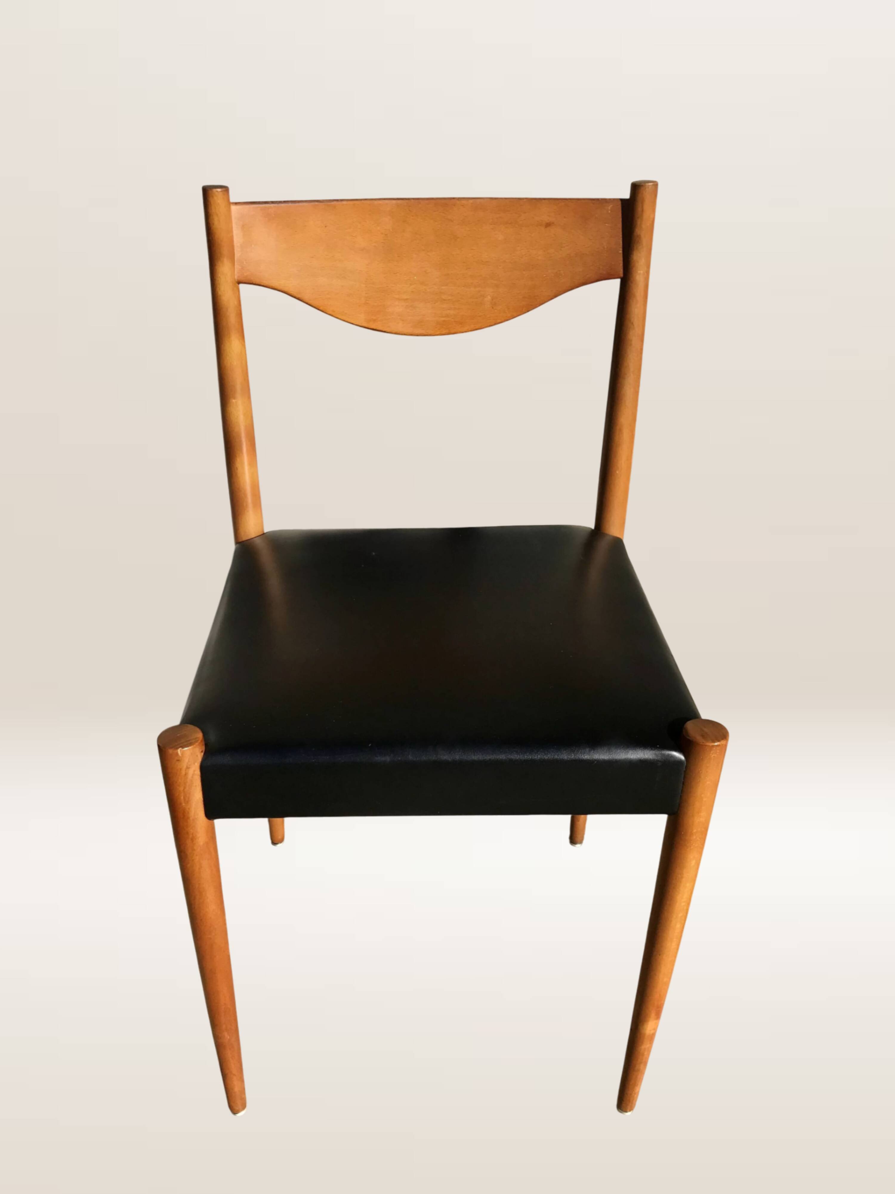 Set of 6 modernist chairs with black faux leather seats.
