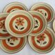 Set 11 plates 1970 Revernay Sarreguemines orange and brown on sandstone background