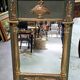 Empire-style mirror in deep green lacquered wood richly enhanced.