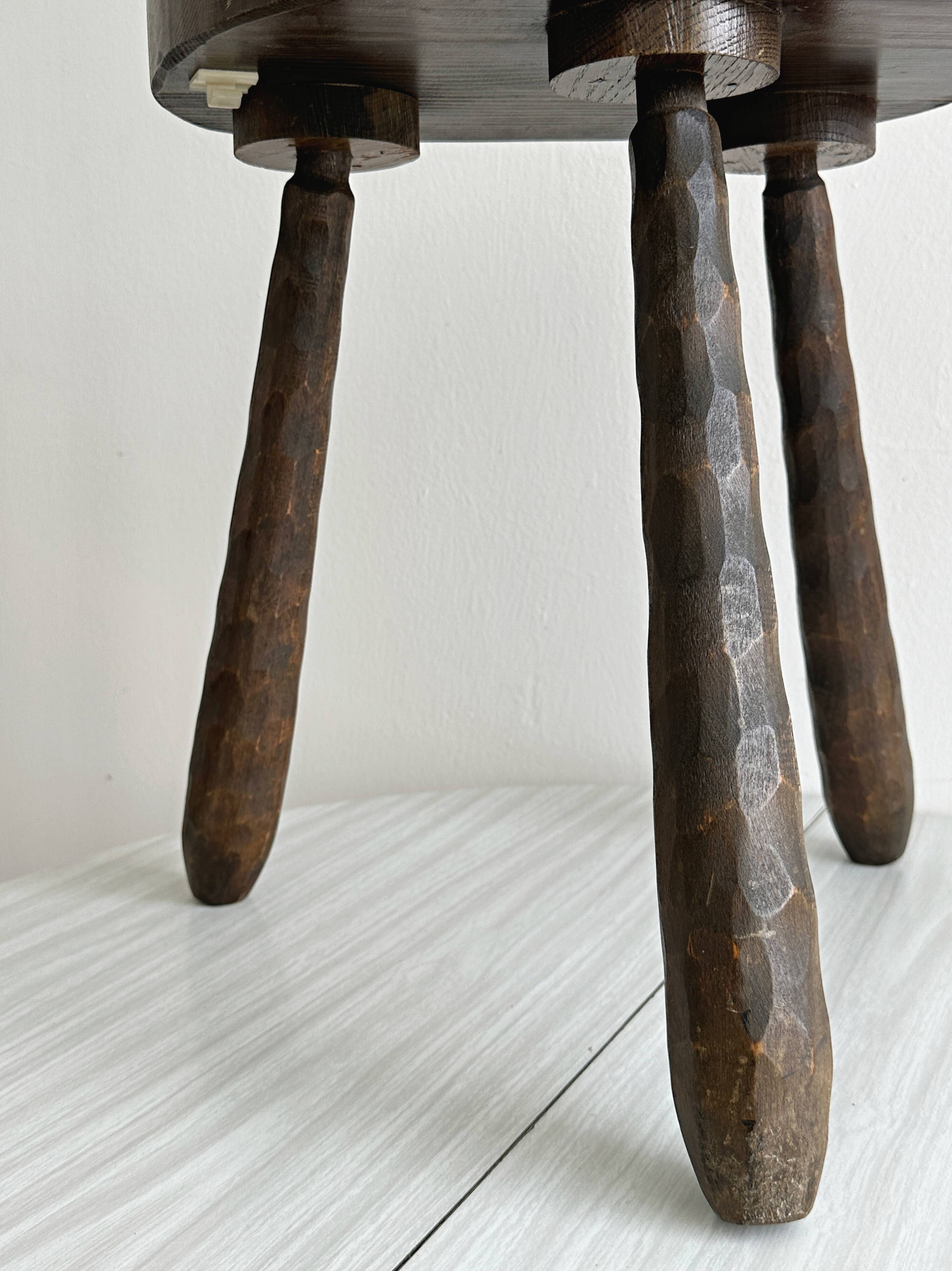 Tabouret tripode ancien en bois foncé sculpté