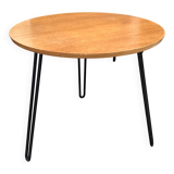 Round side table with black lacquered metal hairpin legs.