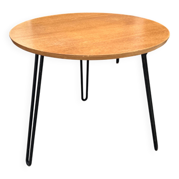 Round side table with black lacquered metal hairpin legs.