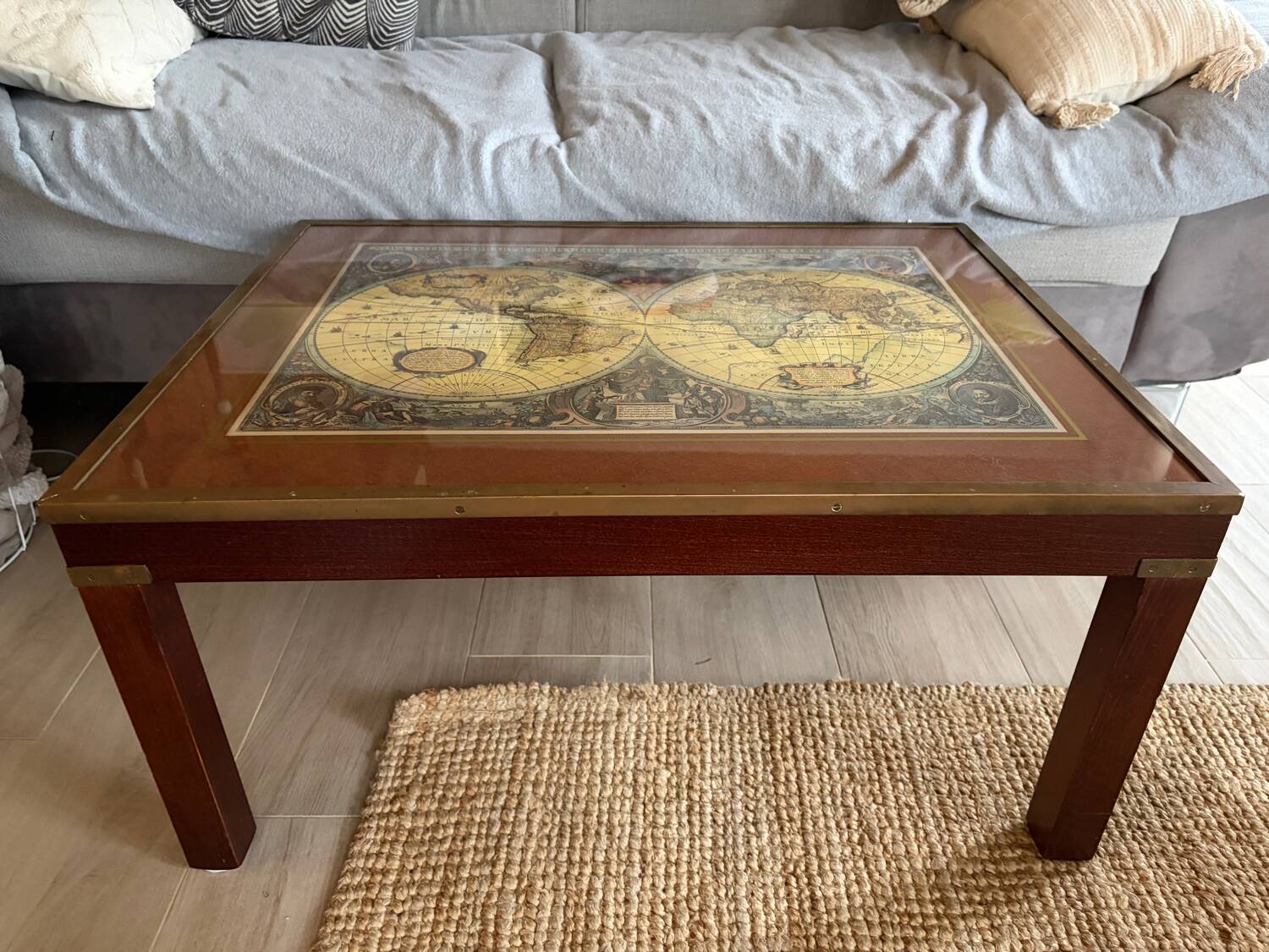Wood and brass coffee table with a world map under glass.
