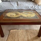 Wood and brass coffee table with a world map under glass.