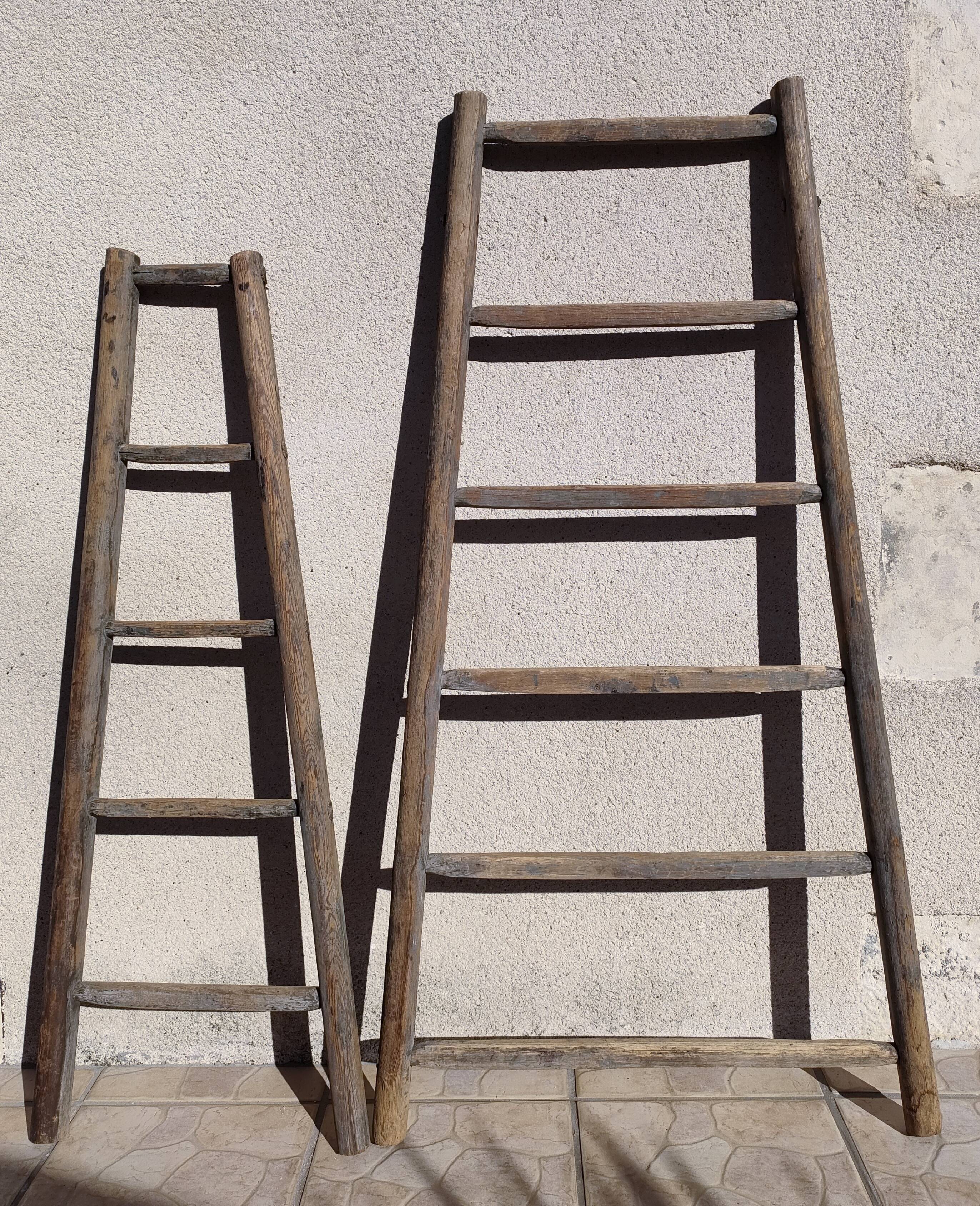 Two weathered wooden ladders H.135 cm