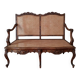 Antique carved solid wood bench with wicker caning.