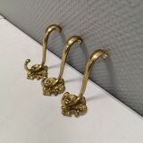 Three old and beautiful brass hooks with decorative motifs