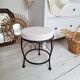 Black iron stool/pouf with its boucle fabric cushion.