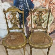 Paire de chaises de musiciens en bois sculpté et doré de style Louis XVI
