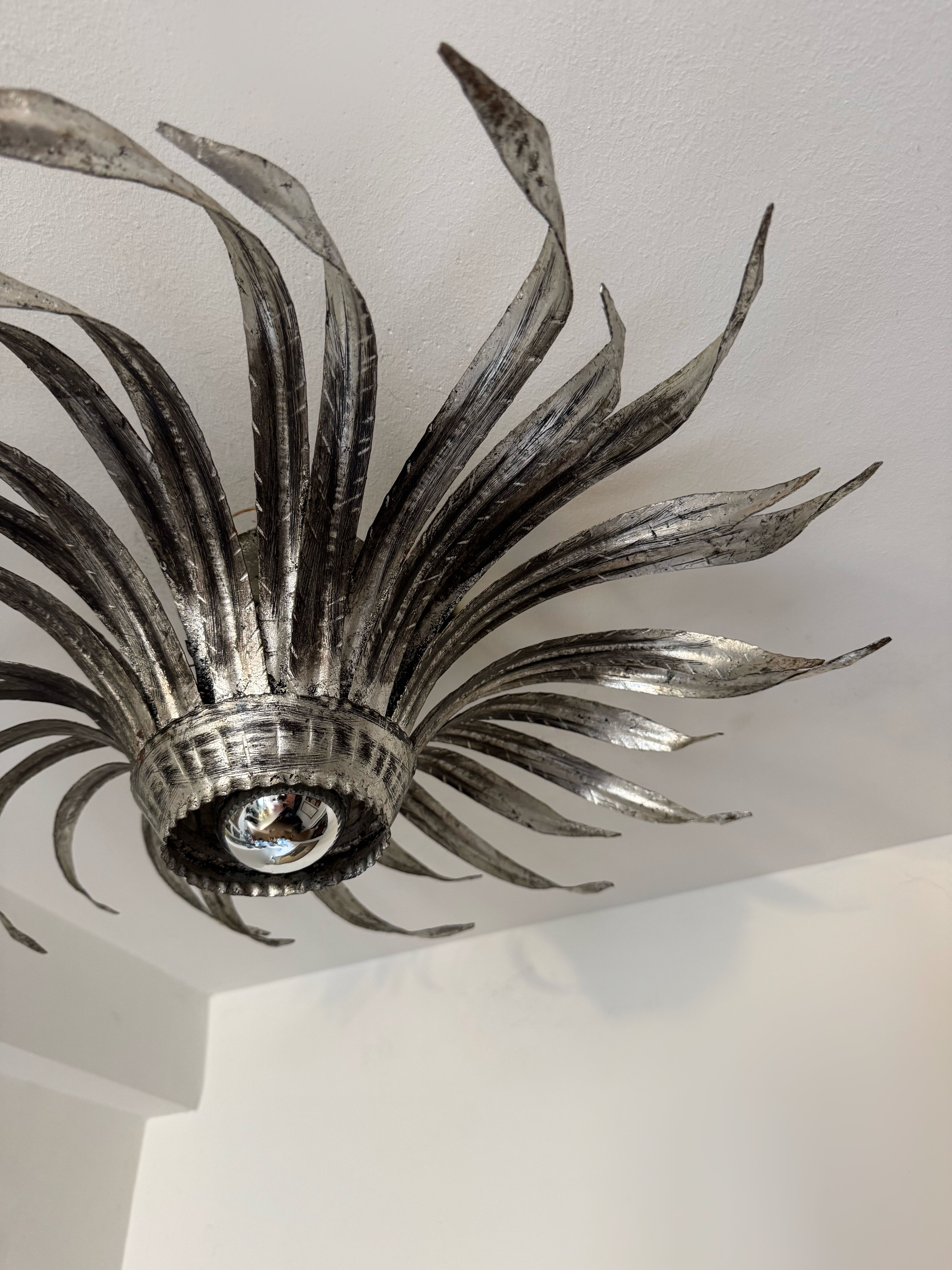 Silver wrought iron sunburst wall light from the 1960s.