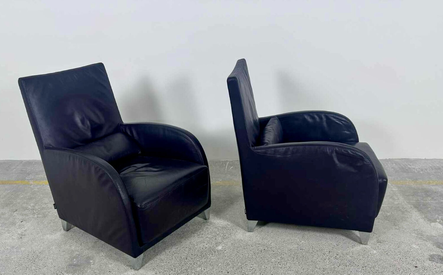 Pair of aubergine leather club armchairs by Cinna.
