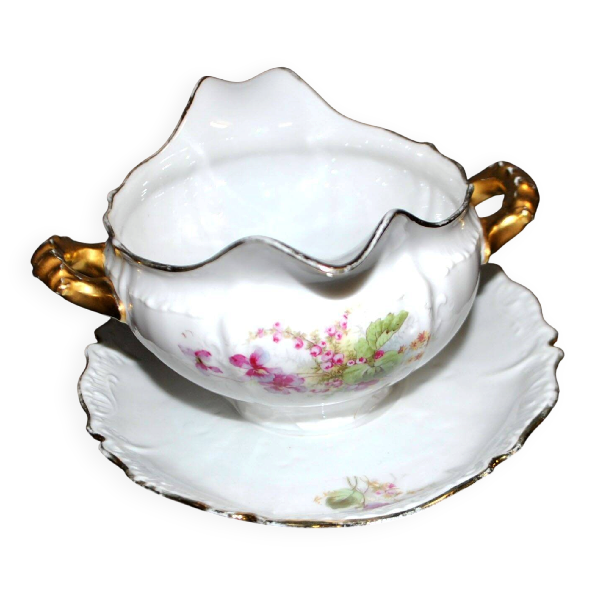 Vintage pouring sauce boat in floral porcelain with gilding.