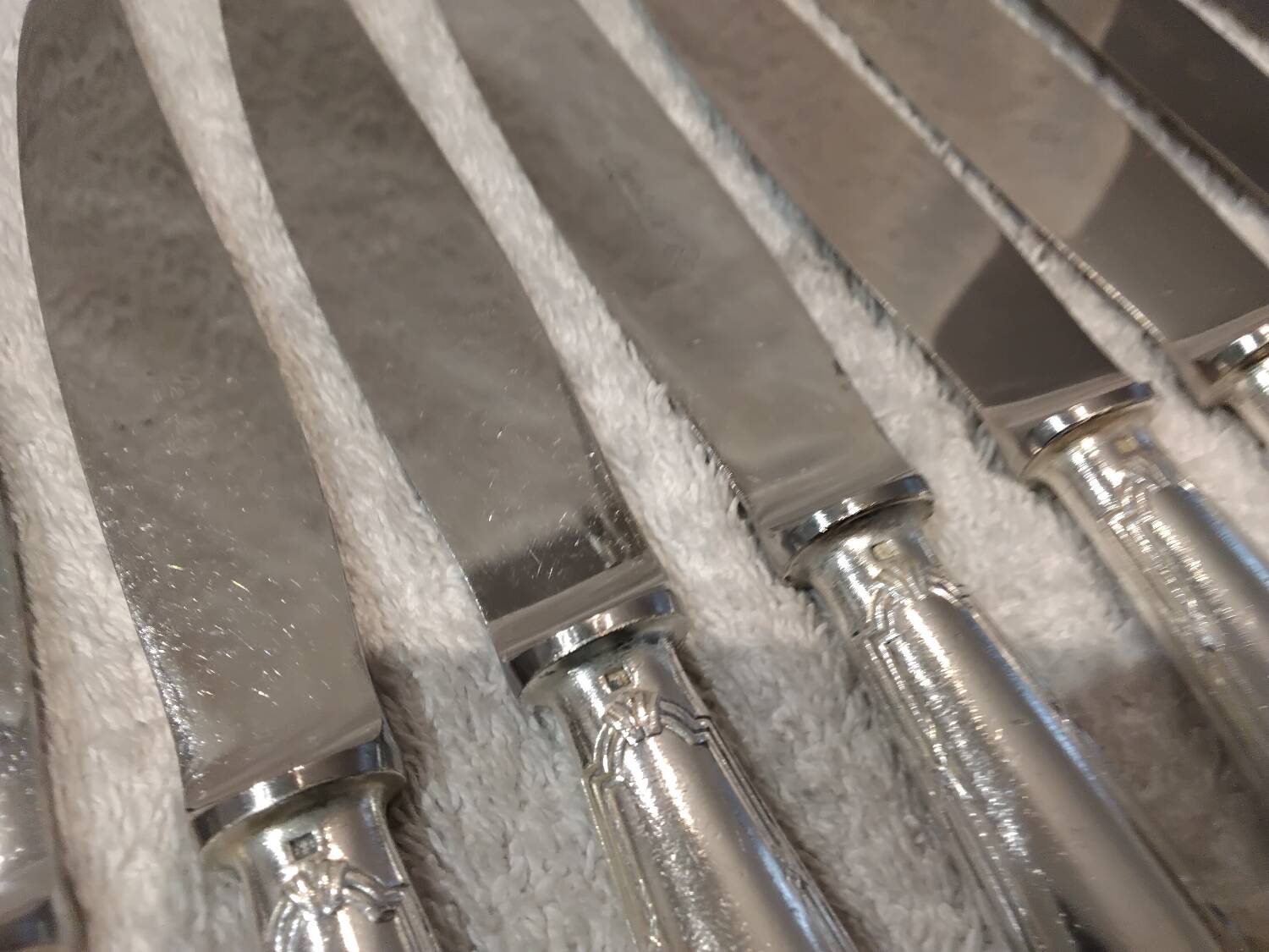 12 silver-plated table knives, Christofle goldsmith ribbons