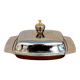 Vintage silver-plated metal butter dish with a gold tassel knob
