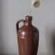 Vintage stoneware liqueur bottle with handle and spout.