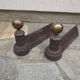 Pair of old cast iron chenets and brass ball